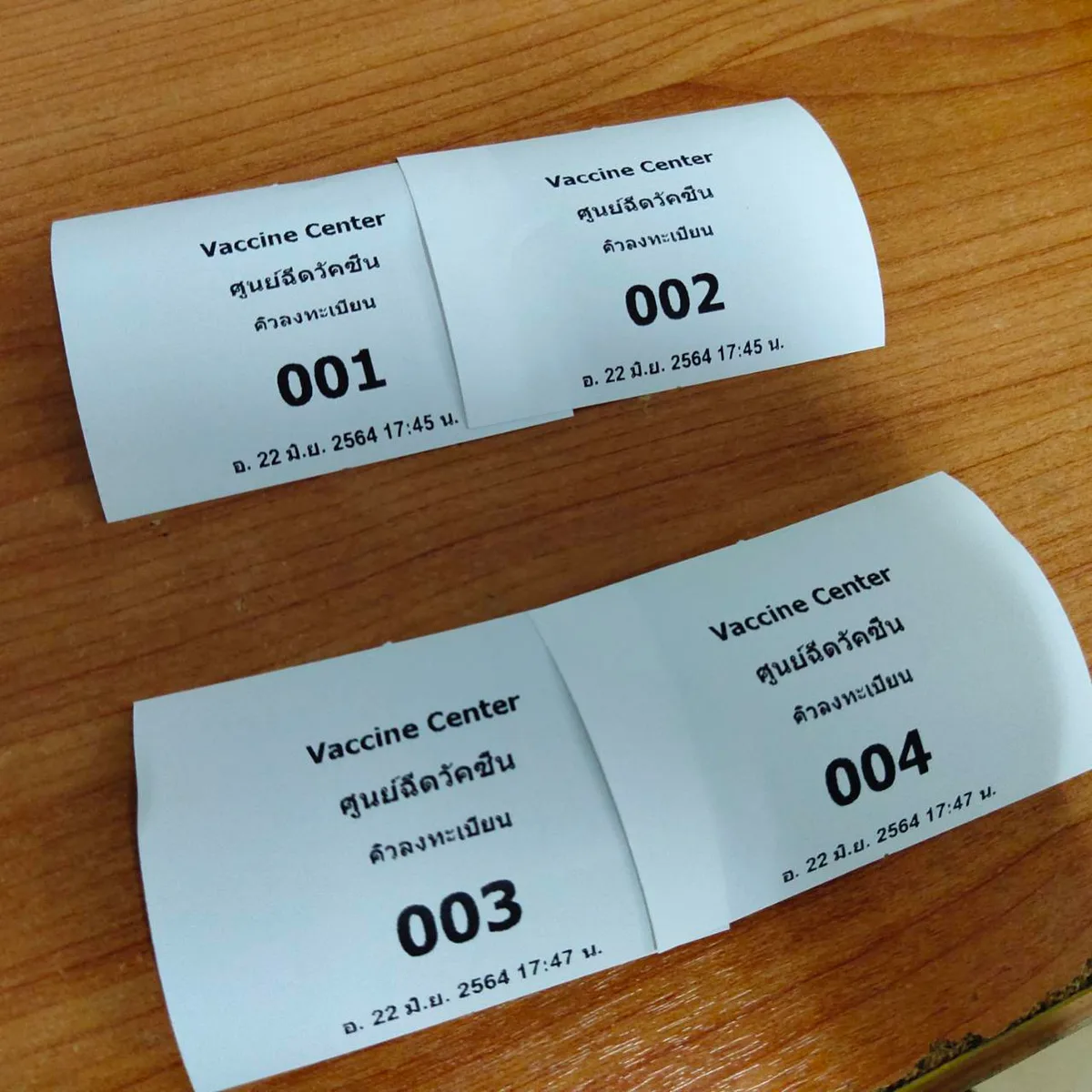 ตัวอย่างบัตรคิวที่พิมพ์จากโปรแกรม เลขคิว 001–004 พร้อมชื่อจุดบริการและวันเวลา